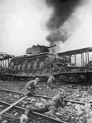 Wermacht'a bağlı Alman askerleri Smolensk'te tank sevkiyat hattını ele geçirmek için ön cephede çarpışıyor. Fotoğrafta görülen tank Sovyet Kliment Voroşilov tankı (KV 1 Tank) (Ağustos 1941)